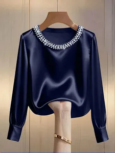 Close-up of navy blue satin blouse with pearl round neck, showing fabric texture and drape