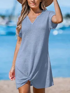 Vista dettagliata di un mini abito azzurro in maglia a nido d'ape con scollo a V e nodo