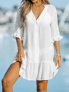 Woman wearing a loose white V-neck beach cover-up dress with ruffle details