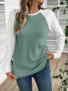 Détail d'un t-shirt gaufré pour femme avec manches raglan bicolores vert et blanc.