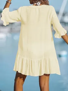 Back view of a loose cream ruffle dress featuring crinkled fabric texture for beach wear