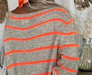 Vue détaillée de la texture tricotée à rayures gris et orange d'un pull de haute qualité