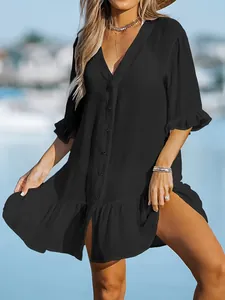 Detailed close-up of a black loose V-neck beach dress with ruffle hem and button design