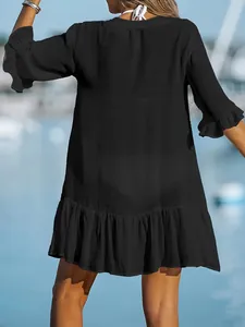 Back view of black loose ruffle beach dress cover-up with textured fabric.