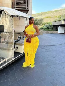 Vibrant yellow crochet two-piece set with long fringe skirt for resort vacations.