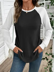 Vue détaillée de la texture en maille gaufrée d'un t-shirt à manches raglan noir et blanc.