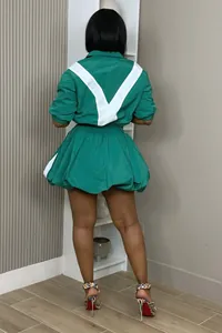 Back view of a casual green and white color-block jacket and bubble skirt set for women