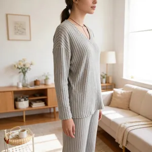 Seitenansicht einer Frau in grauem, weit geripptem Loungewear-Set mit V-Ausschnitt