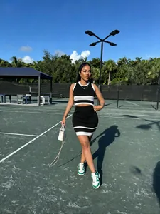 Vista de cuerpo completo de mujer con conjunto de falda corta de punto a rayas blancas y negras