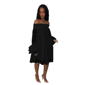 Detail view of a black off-the-shoulder dress with polka dot jacquard texture
