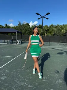 Mujer con conjunto de punto verde y blanco de top corto y minifalda en la cancha