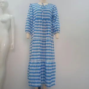 Detailansicht eines blau-weißen Maxikleids mit geometrischem Rautenmuster und Puffärmeln