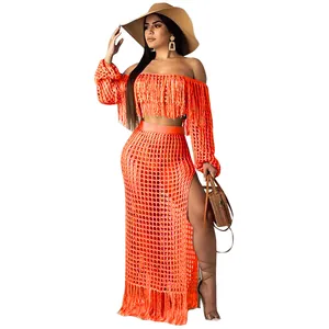 Detail of orange mesh fringe two-piece beach set featuring off-shoulder top and long skirt