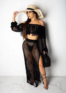 Detailed view of black crochet mesh two-piece set with long fringe on skirt and top.