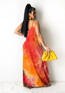 Back view of a vibrant orange tie-dye maxi slip dress on a model holding a yellow clutch