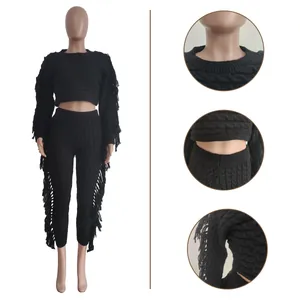 Detail view of black cable knit two-piece set featuring stylish fringe on sleeves and pants.