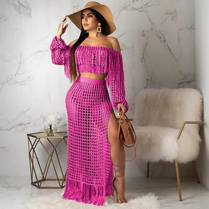 Pink crochet mesh two-piece beach set with tassels and high slit detail.