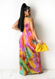 Back view of a vibrant tie-dye cotton slip maxi dress paired with yellow accessories.