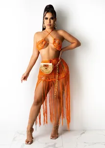 Close-up detail of sexy orange crochet knit two-piece beach set with long fringe skirt