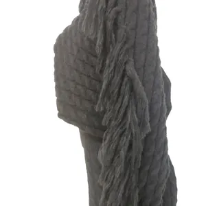 Close-up detail showing the textured black knit fabric with long fringe on casual set