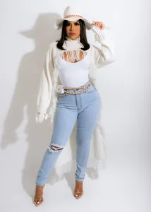 Detail view showing the soft knit texture and long fringe on white cardigan