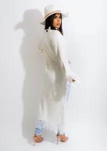 Detailed view of a white long-line knitted cardigan with stylish fringe hem details.