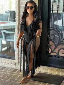 Full-length detail of a black hollow-out knitted swimsuit featuring long fringe accents
