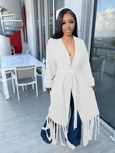 Detailed view of white long-sleeve knit cardigan with fringe hem and tie waist