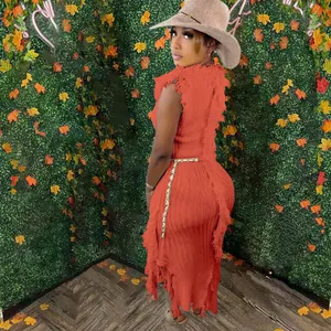 Detailed back view of orange sleeveless knitted dress featuring fringe hem and gold belt