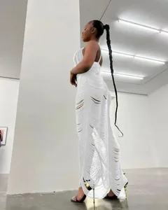 Vista dettagliata di un abito lungo bianco a maglia senza maniche con design traforato.