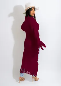 Detailed shot of a long maroon sweater cardigan with fringe trim on hem and cuffs