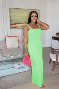 Full body view of a woman wearing a vibrant neon green sleeveless wide-leg jumpsuit.