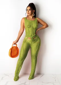 Sexy lime green hollow-out knitted jumpsuit for women shown on a model against white wall