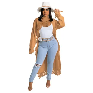 Detail of camel long-line distressed knit sweater with fringe hem and ripped accents.