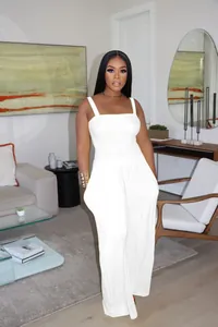 Full-body detail showing the fit of a white smocked wide-leg jumpsuit on a model