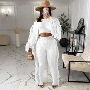 Detailed view of white knitted two-piece set with long fringe accents and texture