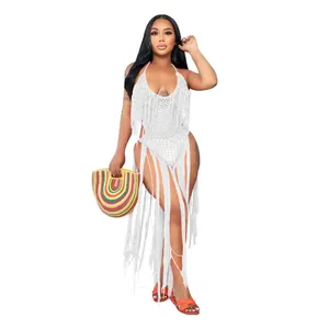 Detailed view of white crochet swimsuit with long fringes on a fashion model posing