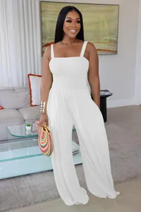 Elegant white smocked wide-leg jumpsuit with spaghetti straps worn by a professional model.