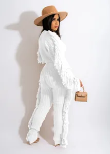 Detailed view of a white cable knit two-piece outfit featuring long fringe accents.