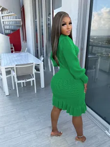 Dettaglio dell'abito in maglia verde a collo alto con motivo a trecce e bordo con balze