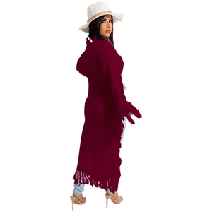 Macro view of a long burgundy knit sweater featuring stylish fringe detail for women.