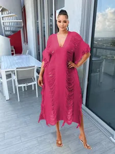 Detailed view of a fuchsia handmade knitted dress featuring fringe and cutouts