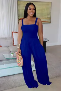 Royal blue sleeveless wide-leg jumpsuit for women in a modern living room setting.
