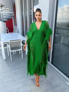 Elegant green hand-knit sheer maxi dress with fringe details for beach and resort wear