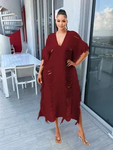 Detailed shot of a maroon handmade knit fringe maxi dress with hollow out V-neck design
