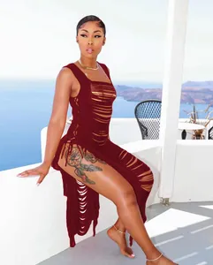 Detailaufnahme einer Frau in einem weinroten, gestrickten Strandkleid mit Quasten und Cut-outs