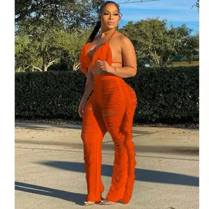 Détail d'un ensemble deux pièces en tricot orange avec bikini à franges et pantalon