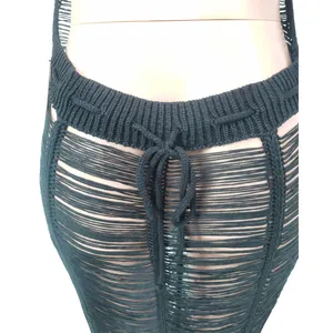 Macro detail of sexy black crochet knit beach maxi skirt featuring cutout string design