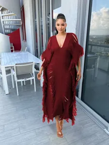 Detailed view of burgundy handmade knitted maxi dress with fringe and cut-outs