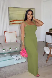 Full body view of a woman in an olive green wide-leg jumpsuit in a living room
